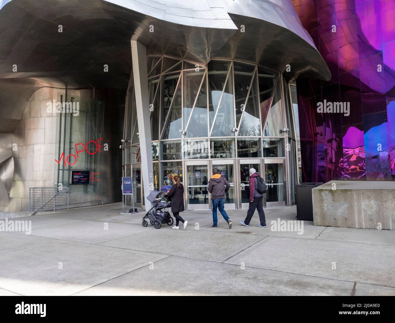Seattle, WA USA - circa March 2022: Family with a baby stroller entering the Museum of Pop Culture on a bright, sunny day. Stock Photo