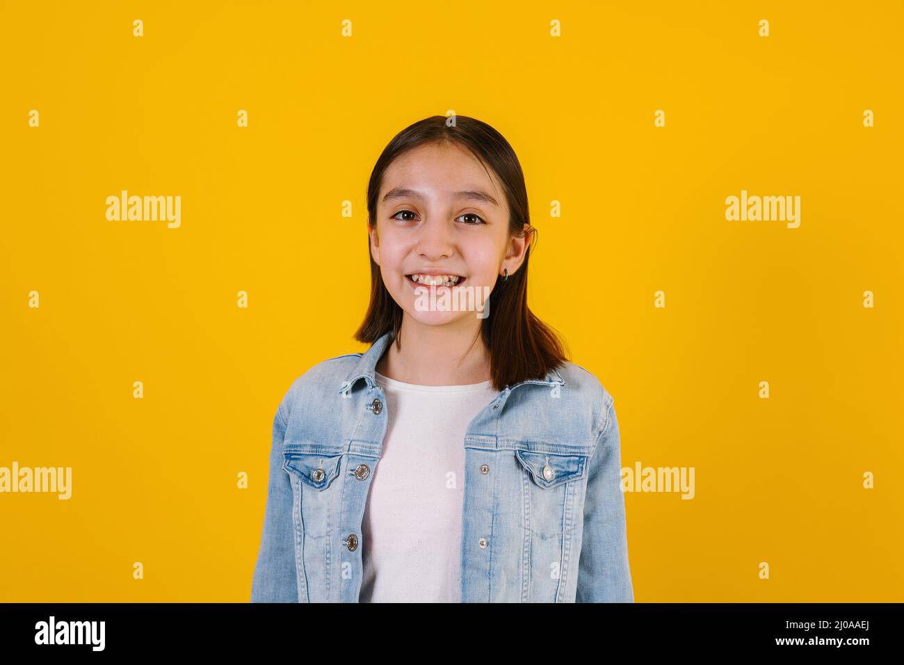 Portrait of hispanic child girl on yellow background in Mexico Latin America Stock Photo