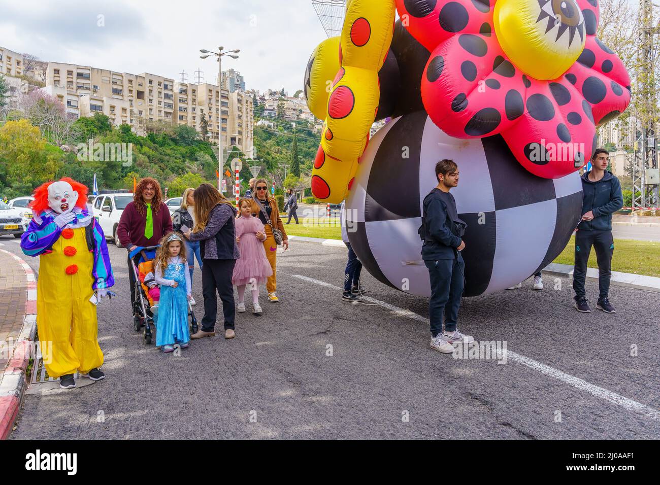 Nesher, Israel - March 17, 2022: Scene of an Adloyada parade of the Jewish holyday of Purim, with inflatable figures, people in costumes and other par Stock Photo