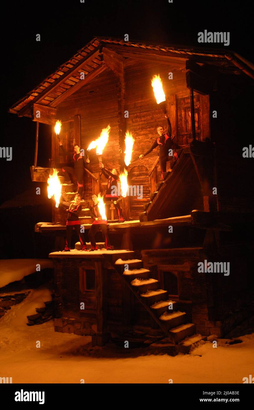 Fire art group in front of wooden house Stock Photo