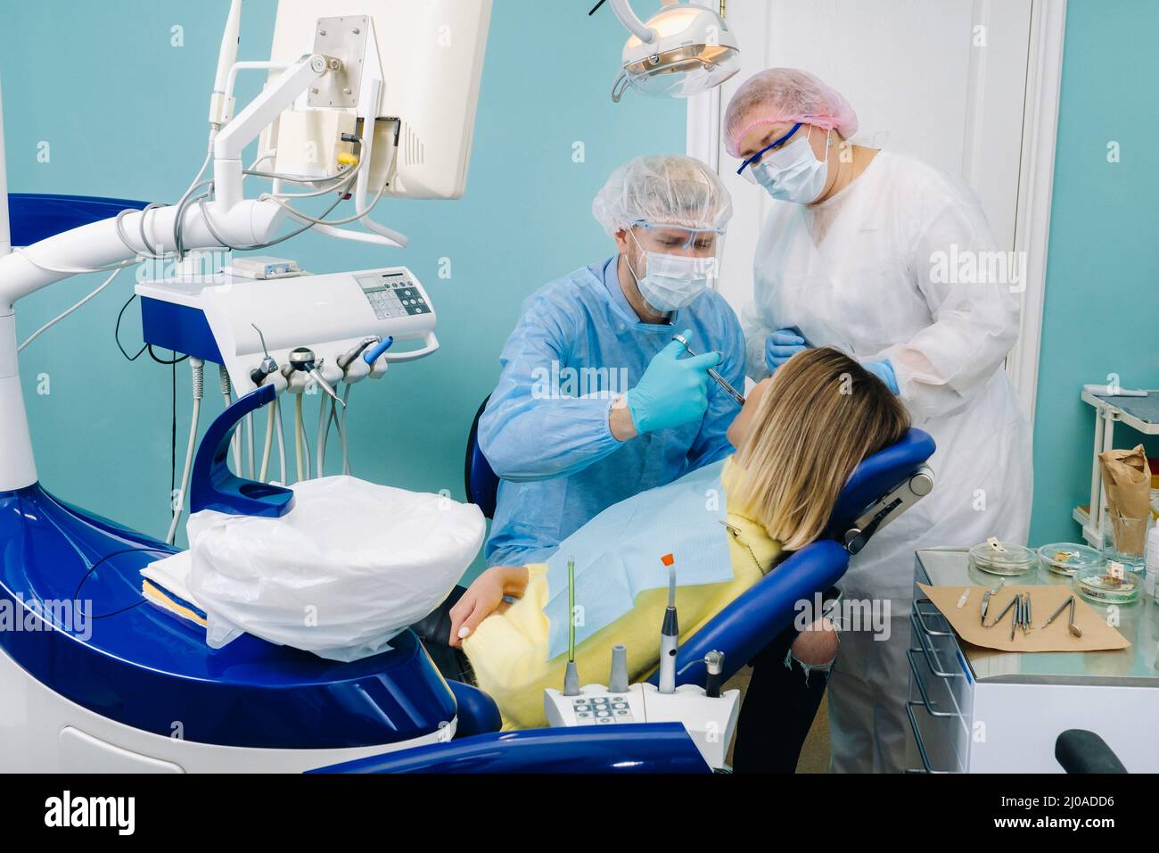 A female patient in dental glasses treats teeth at the dentist with