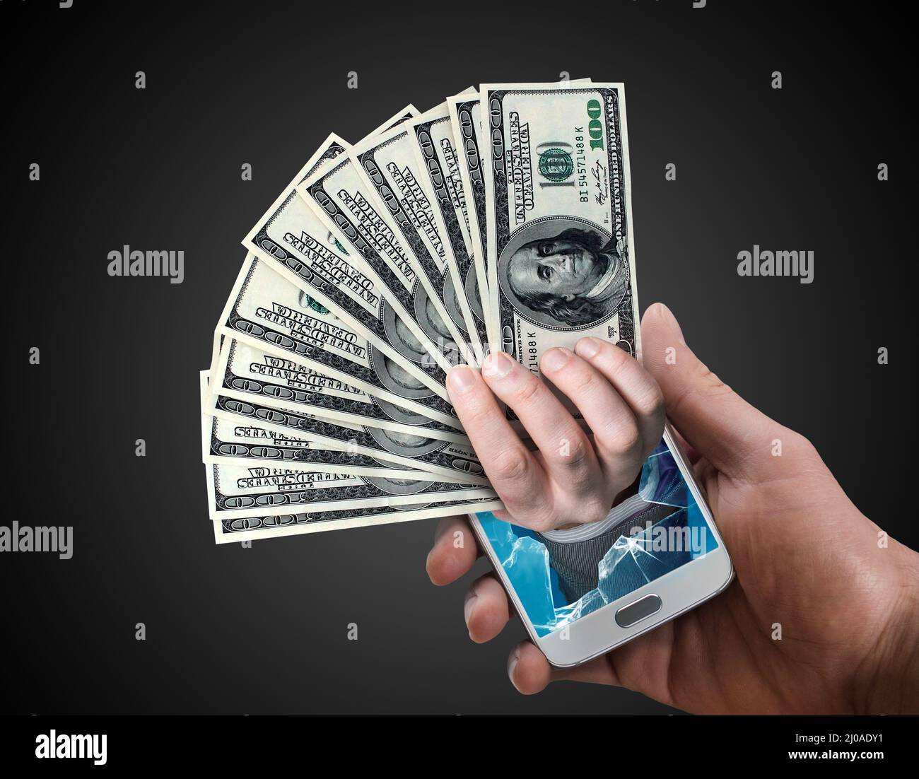 Hand holding dollar cash popping out from a phone screen. Online payment or reward concept. Stock Photo