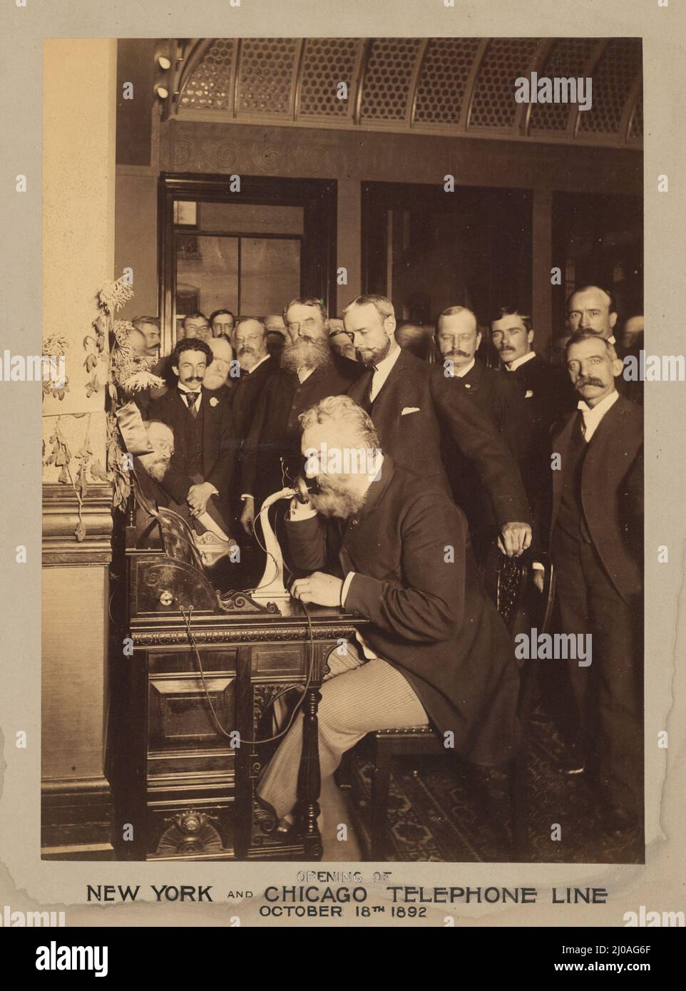 Vintage black and white photograph of American inventor Alexander Graham Bell using a telephone at the opening of the New York and Chicago telephone line in 1892 Stock Photo