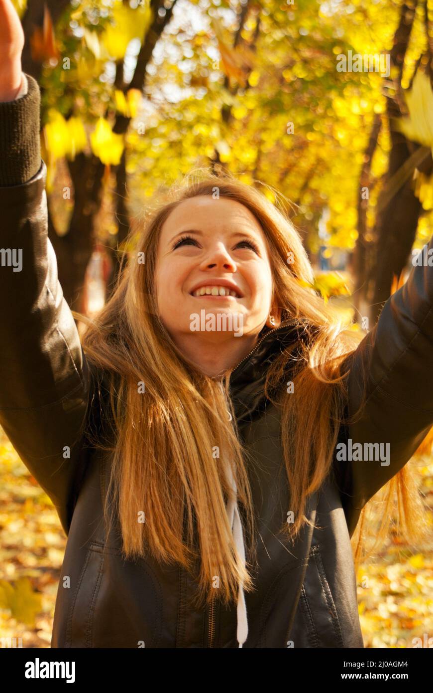 Girl playing with leaves at fall time Stock Photo - Alamy