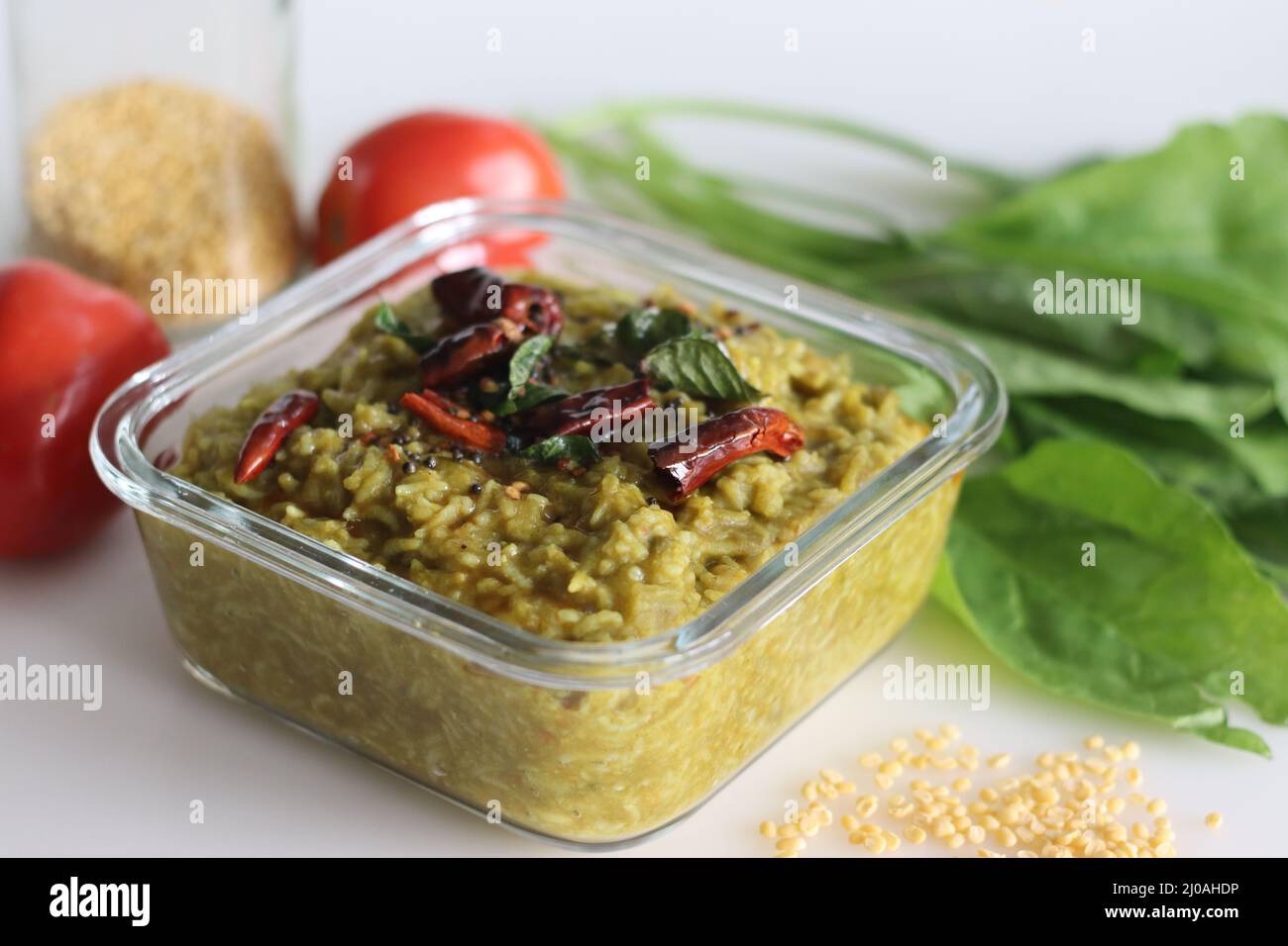 One pot preparation made of basmati rice, yellow mung lentils, blanched and pureed spinach and spices. Commonly known as palak khichdi. Shot on white Stock Photo