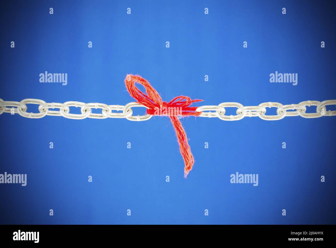Broken chain connected with red threads Stock Photo Alamy