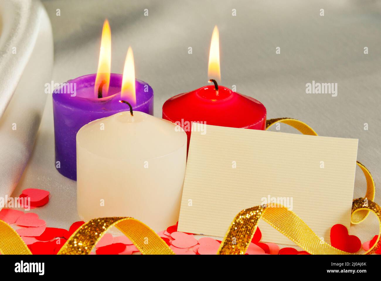 Three burning candles over light background Stock Photo - Alamy