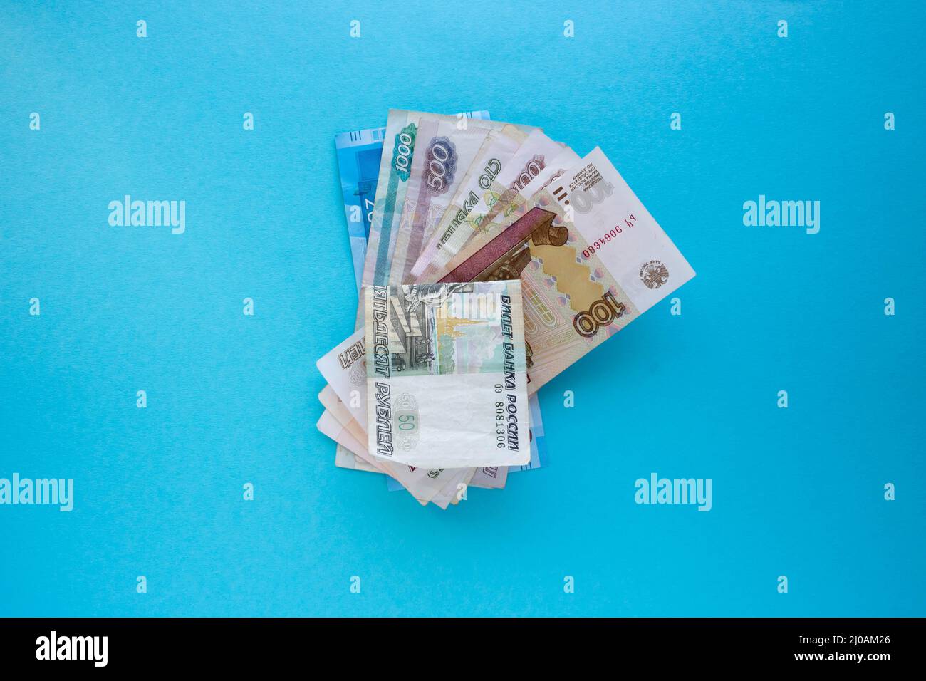 A stack of Russian banknotes. A bundle of Russian money on a blue background. Stock Photo