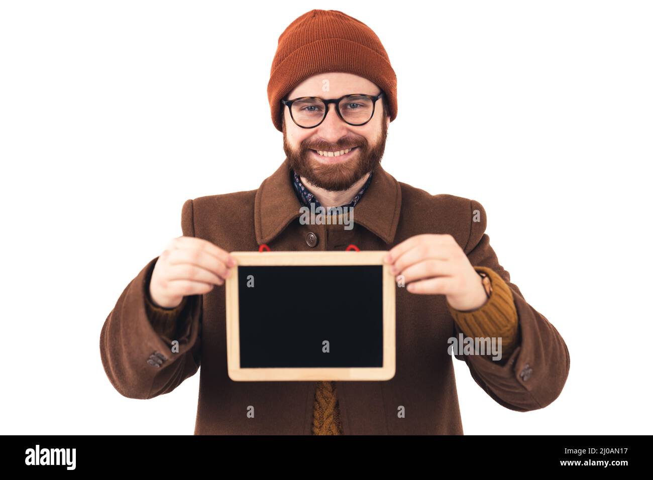 Portrait of a young attractive smiling Caucasian man holding small blackboard brown casual attire isolated studio shot white background . High quality photo Stock Photo