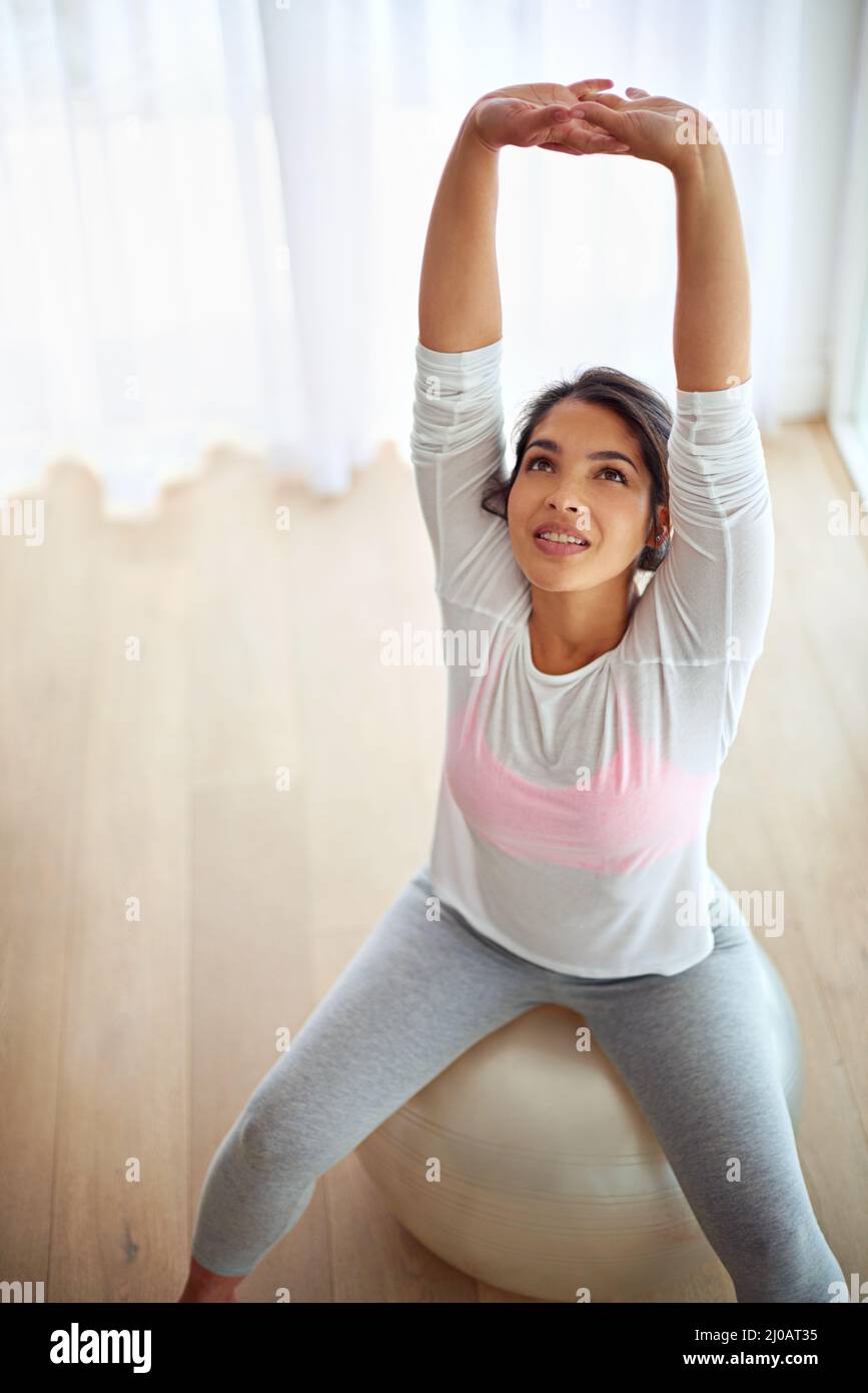 Stretch your limits. Shot of a young woman working out on a fitness ball. Stock Photo