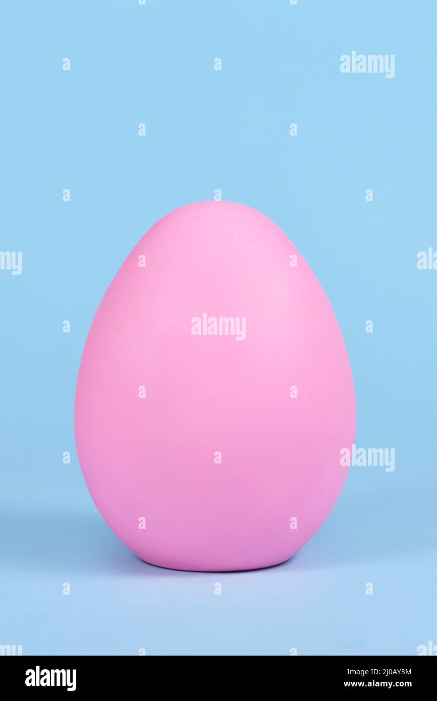 Single pink easter egg on blue background Stock Photo