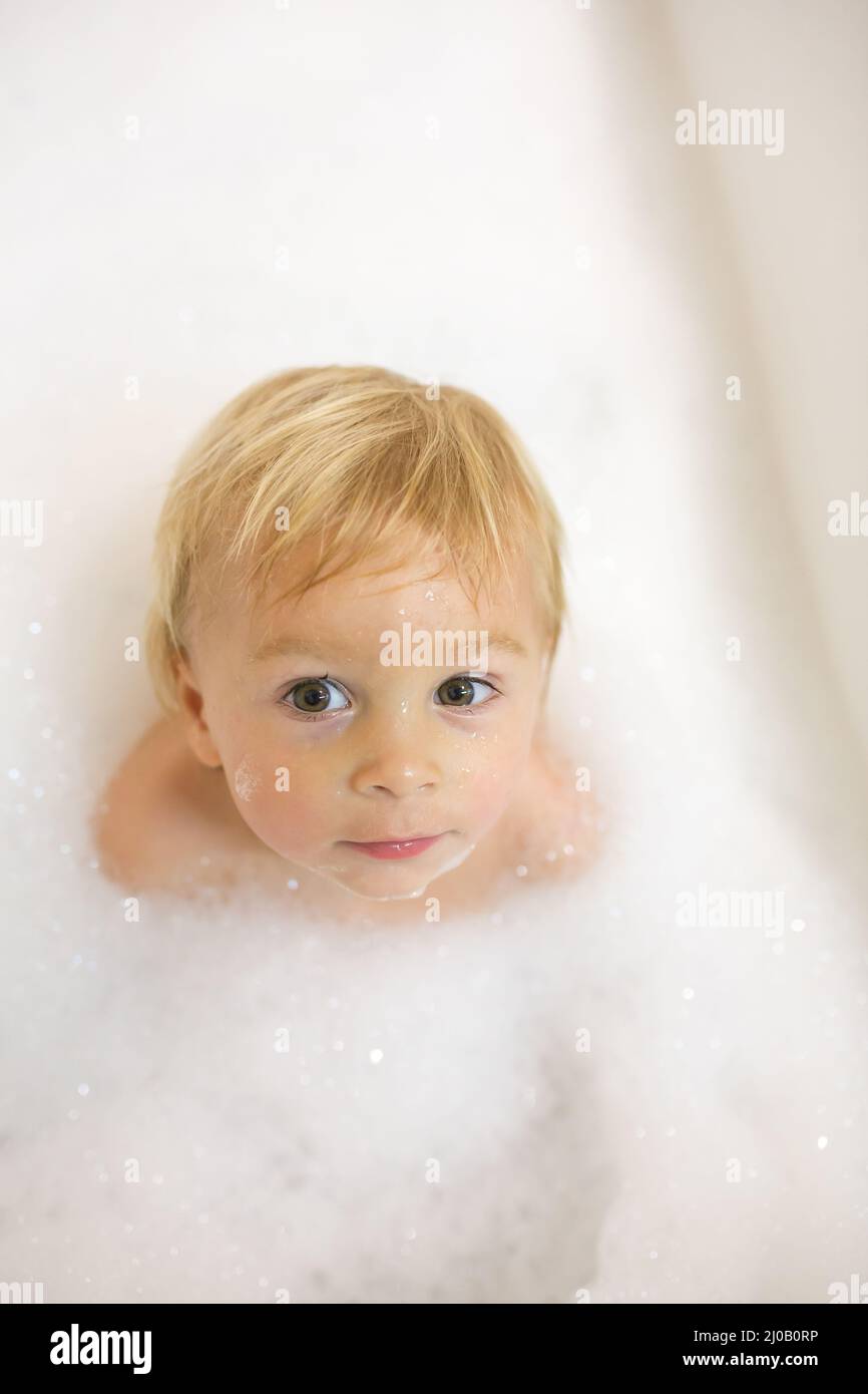 Little boy in bath in the bathroom. Child bathing with a lot of foam