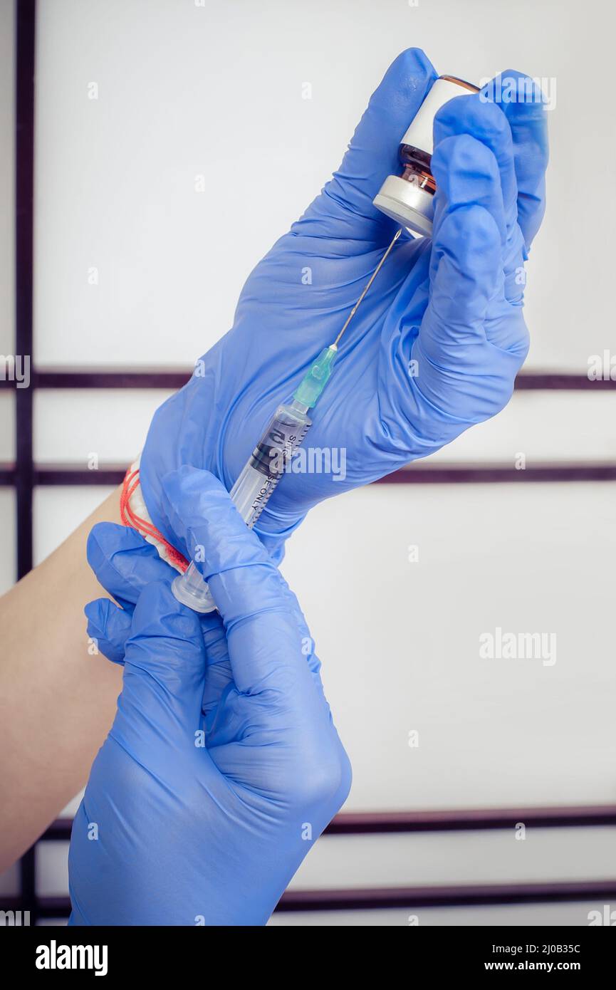 Woman hand with syringe, hypodermic needles and dermal liquid lift. Face treatment Stock Photo