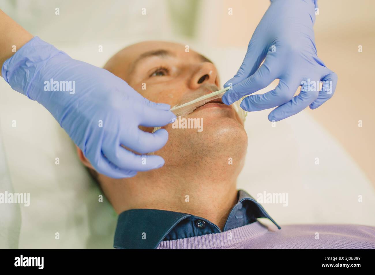 Relaxed man having a face massage and a peeling treatment at a beauty
