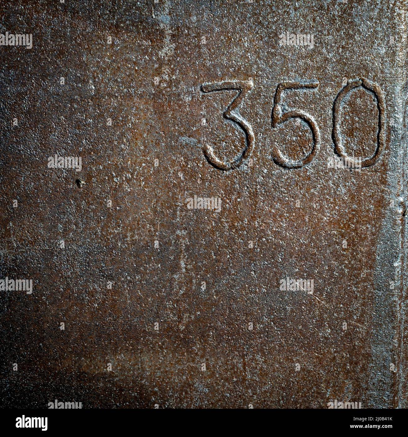 Closeup of a rusty weathered metal surface with the number 350 Stock Photo