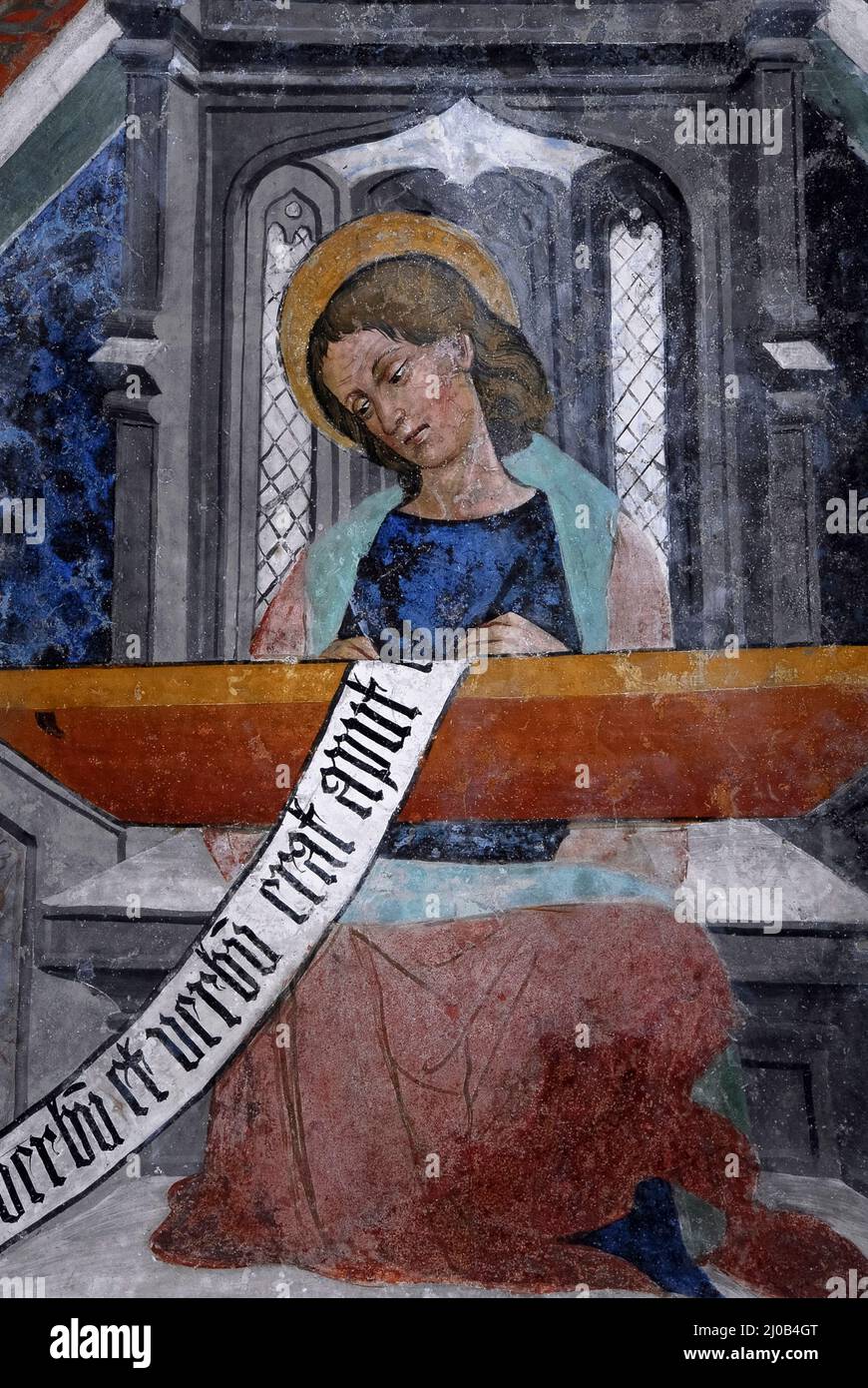 Saint John the Evangelist sits at a desk writing his Gospel in 1400s Piedmontese Late Gothic fresco cycle.  On ceiling vault in the church of the former Franciscan convent at Susa, Piedmont, Italy. Stock Photo
