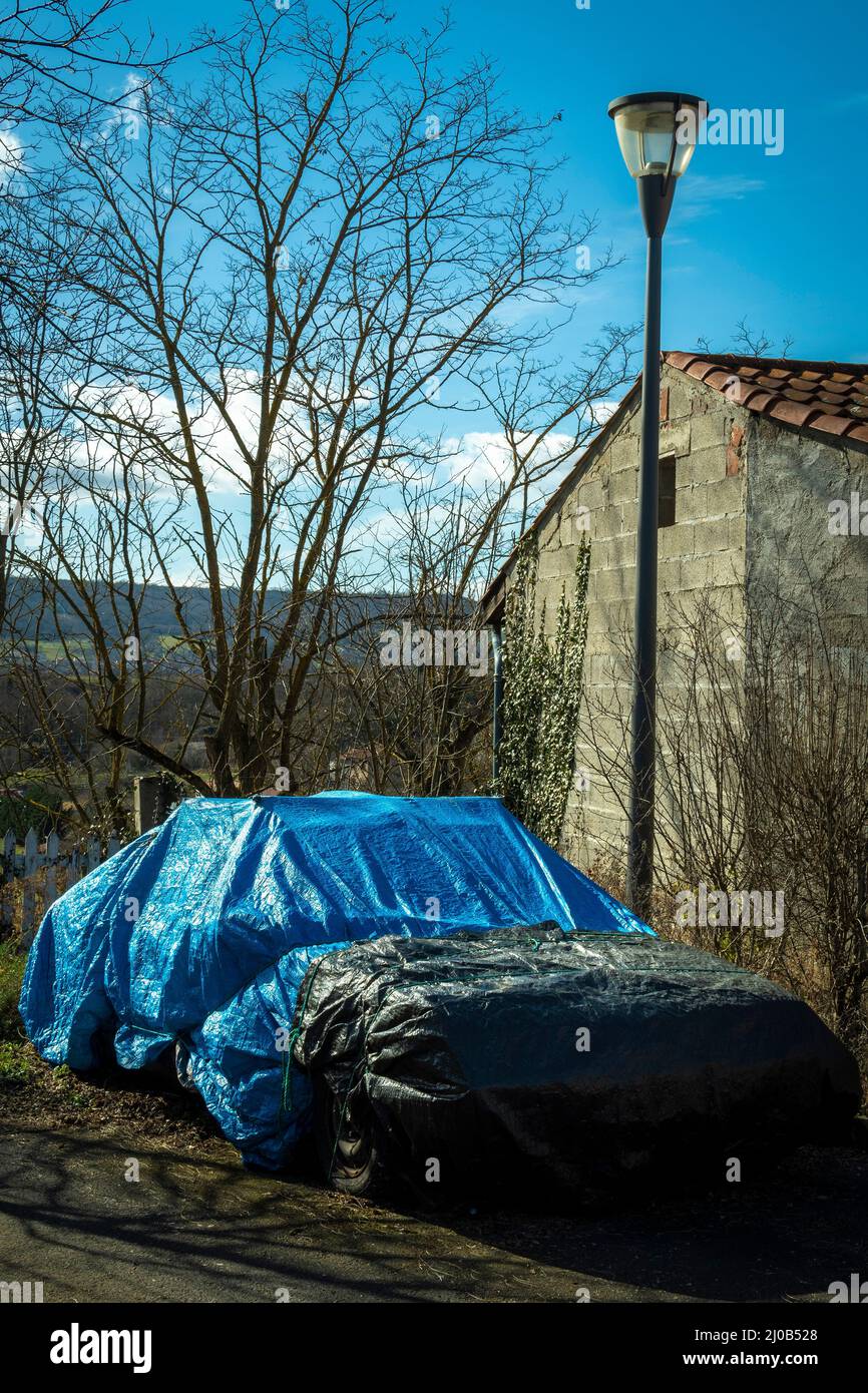 Vertical shot of a parked car under the covers near a building Stock Photo