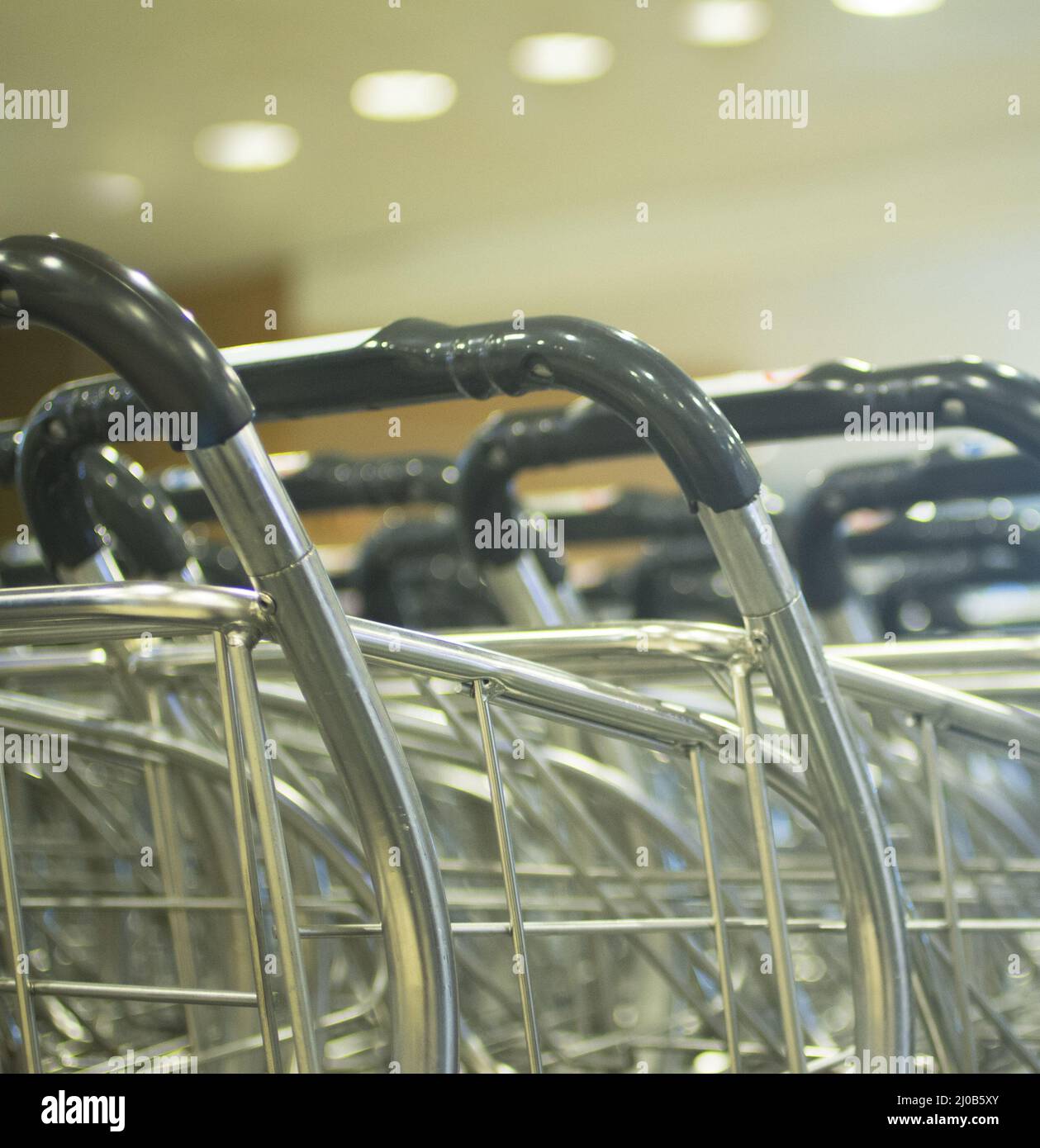 Luggage trolleys in rows in airport arrivals lounge Stock Photo Alamy