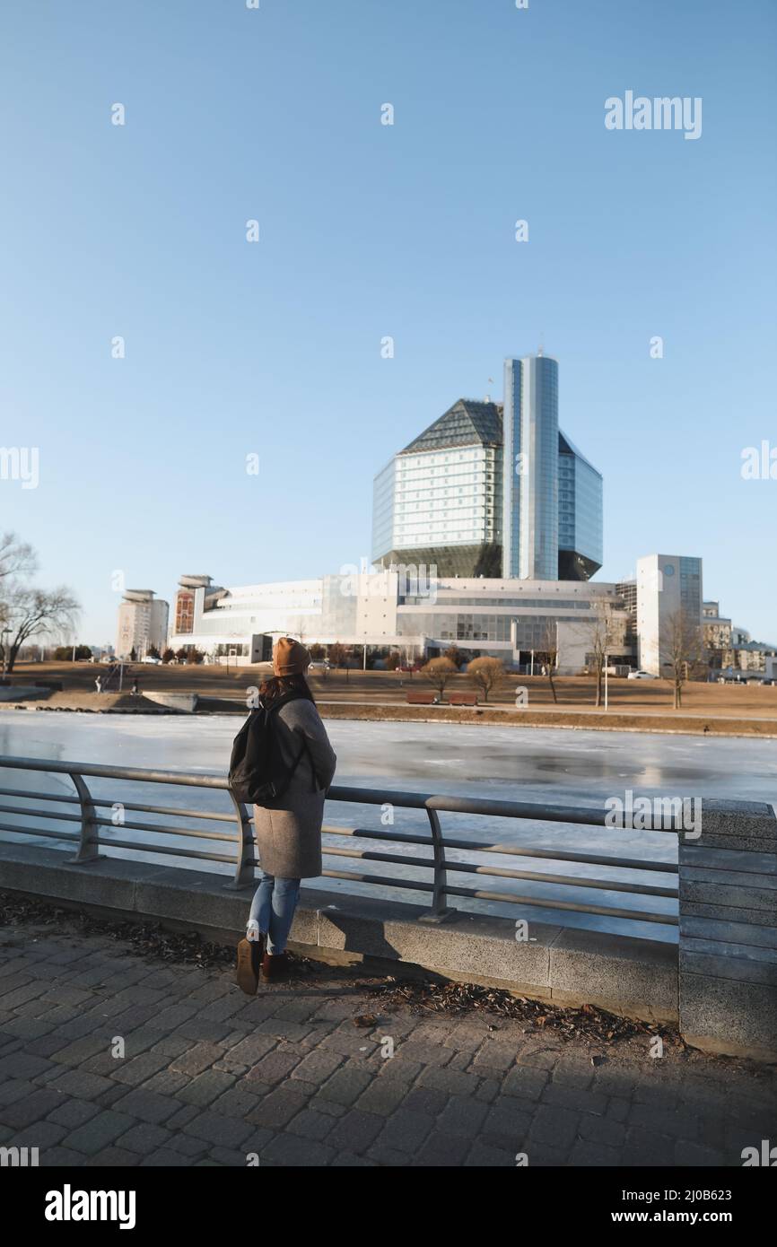 A tourist woman enjoys the view of cityscape of National library of Belarus in Minsk, during spring time Stock Photo