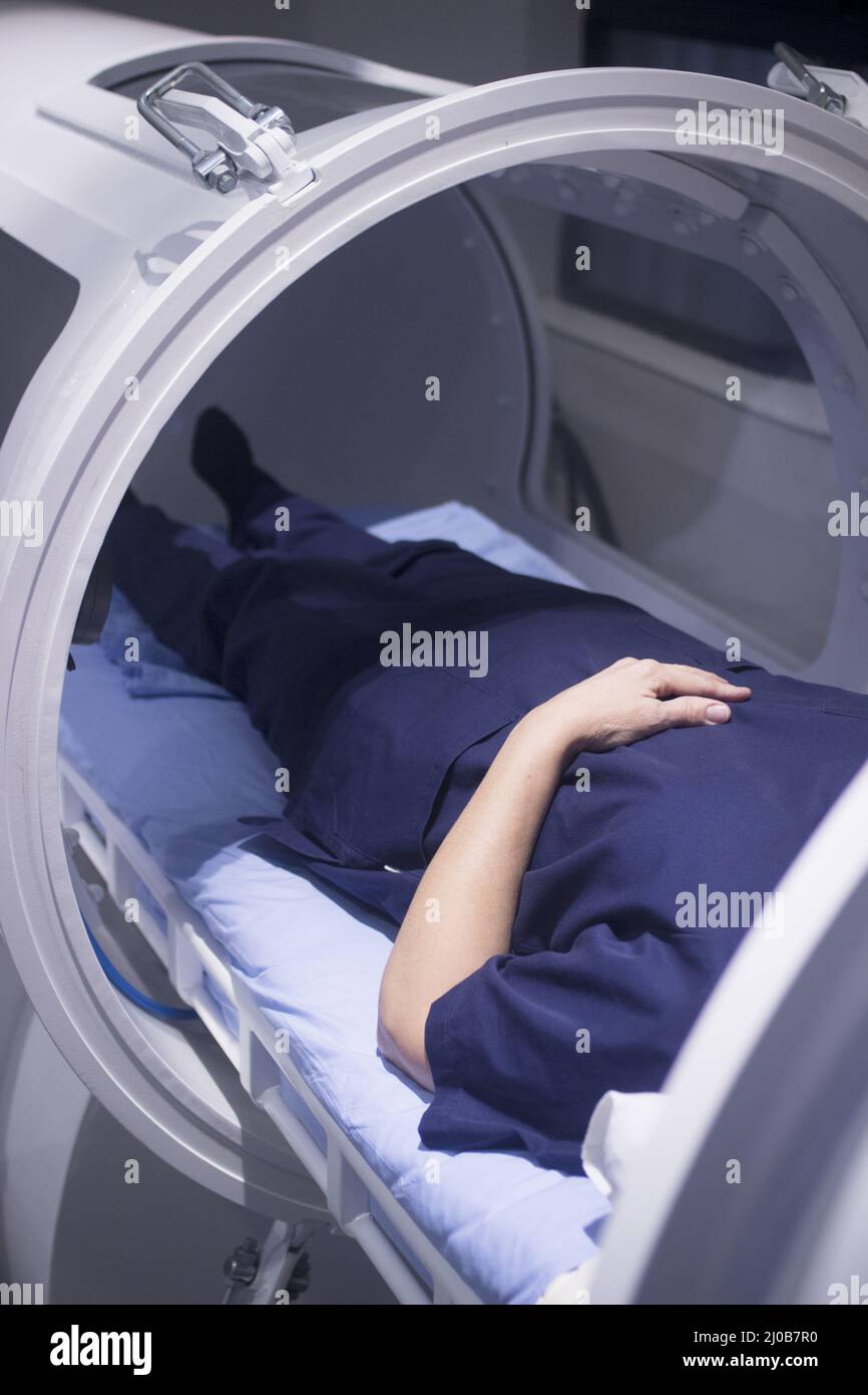 Female patient in oxygen hyperbaric chamber HBOT Stock Photo