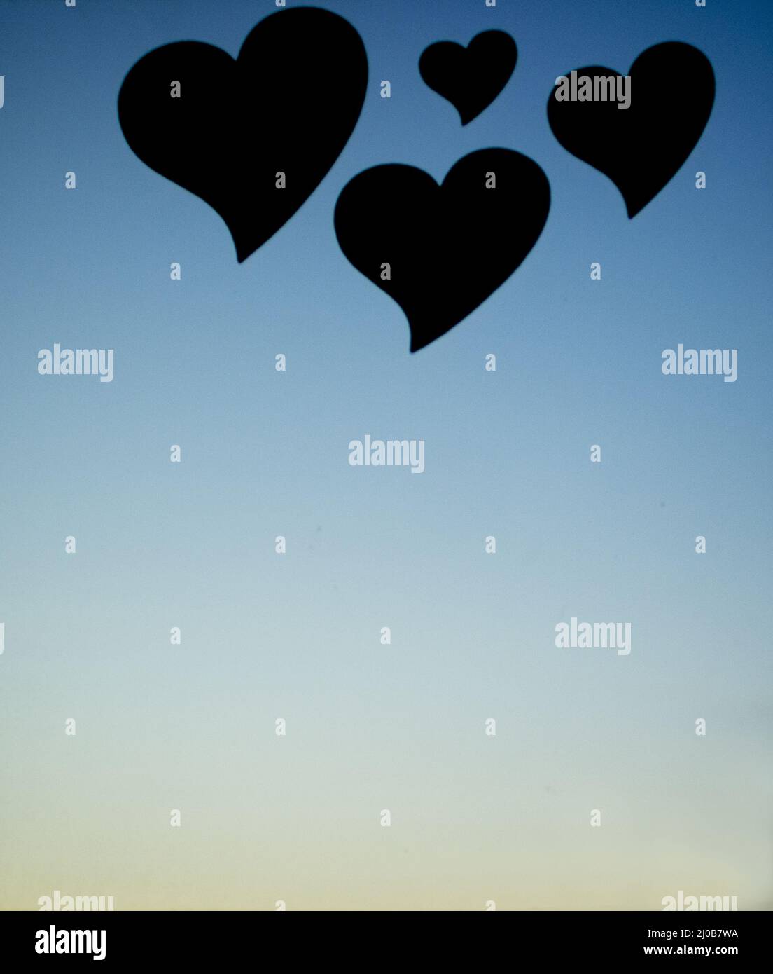 Four love hearts in silhouette with sunset sky background Stock Photo