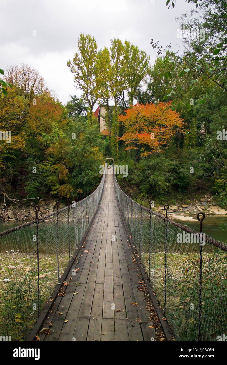 Suspension bridge through the mountain river Stock Photo