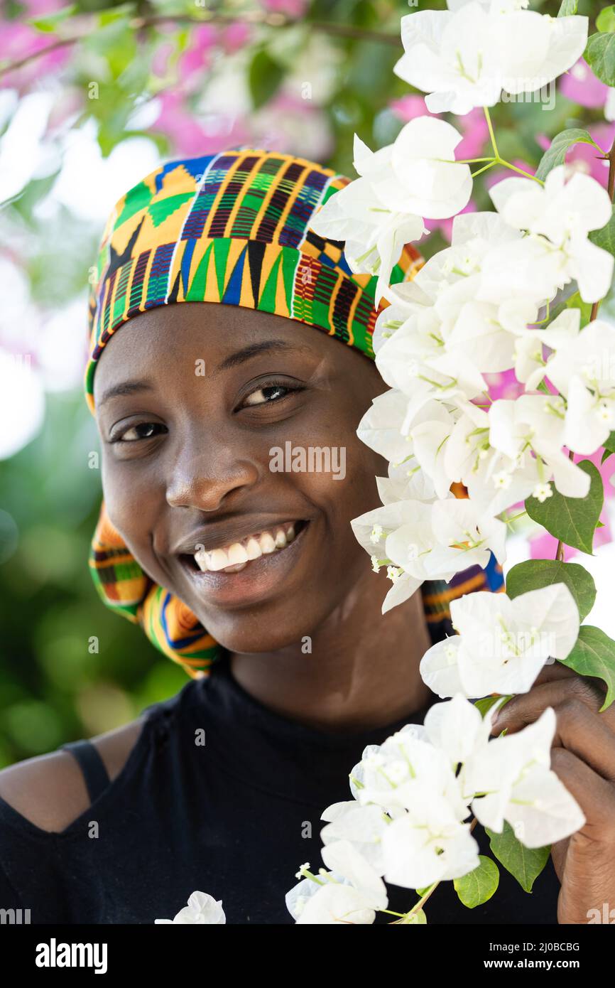 Portrait of a smiling West African girl posing among white and