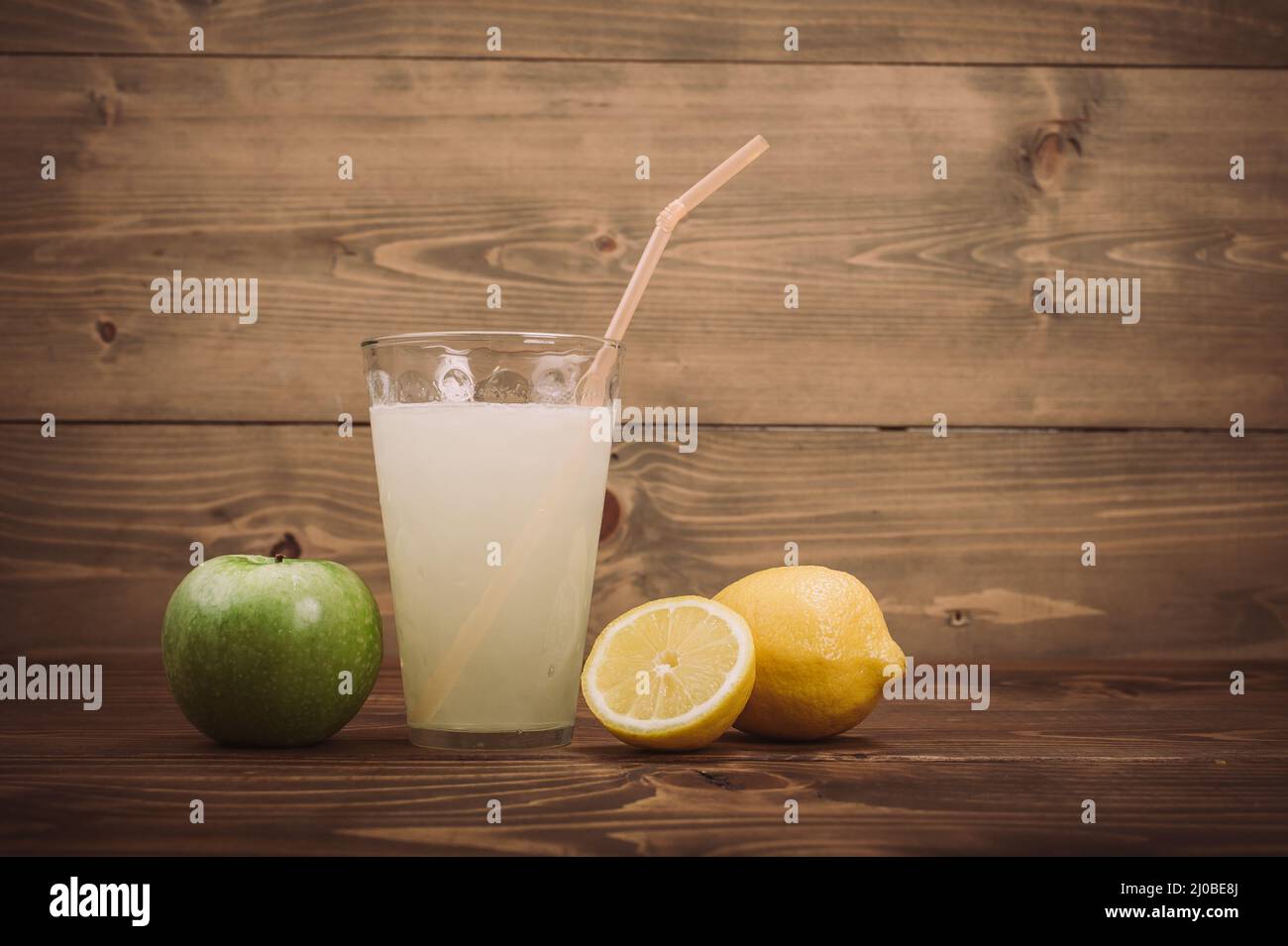 Glass of fresh lemon juice with sliced lemon half. Close up Stock Photo ...