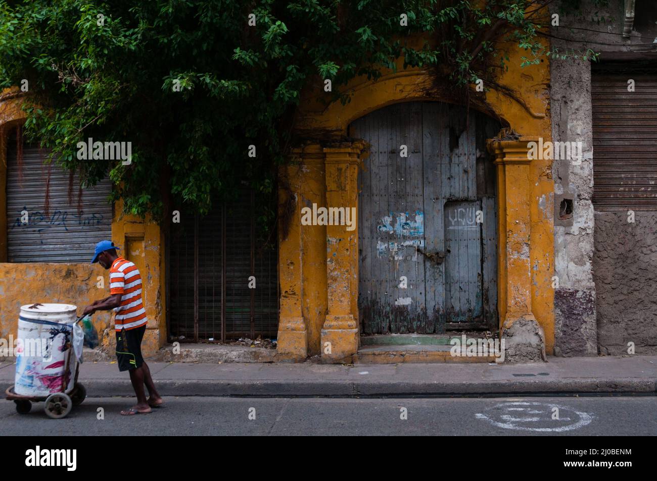Man with cart on street in front of old colonial house Cartagena, Stock Photo