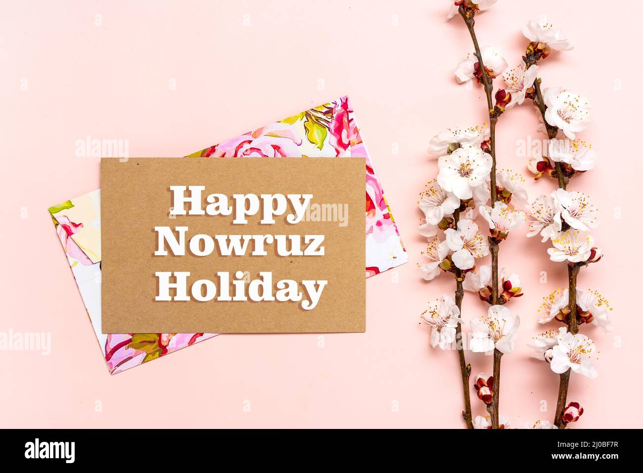 Sprigs of the apricot tree with flowers and Text Happy Nowruz Holiday Concept of spring came Top view Flat lay Hello march, april, may, persian new year. Stock Photo