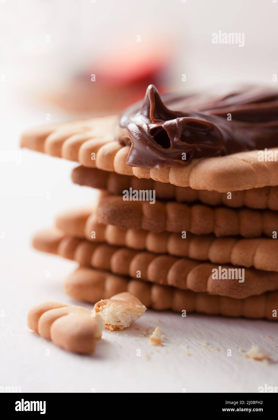 Chocolate sweet melting nougat cream on cookies on a white plate Stock Photo