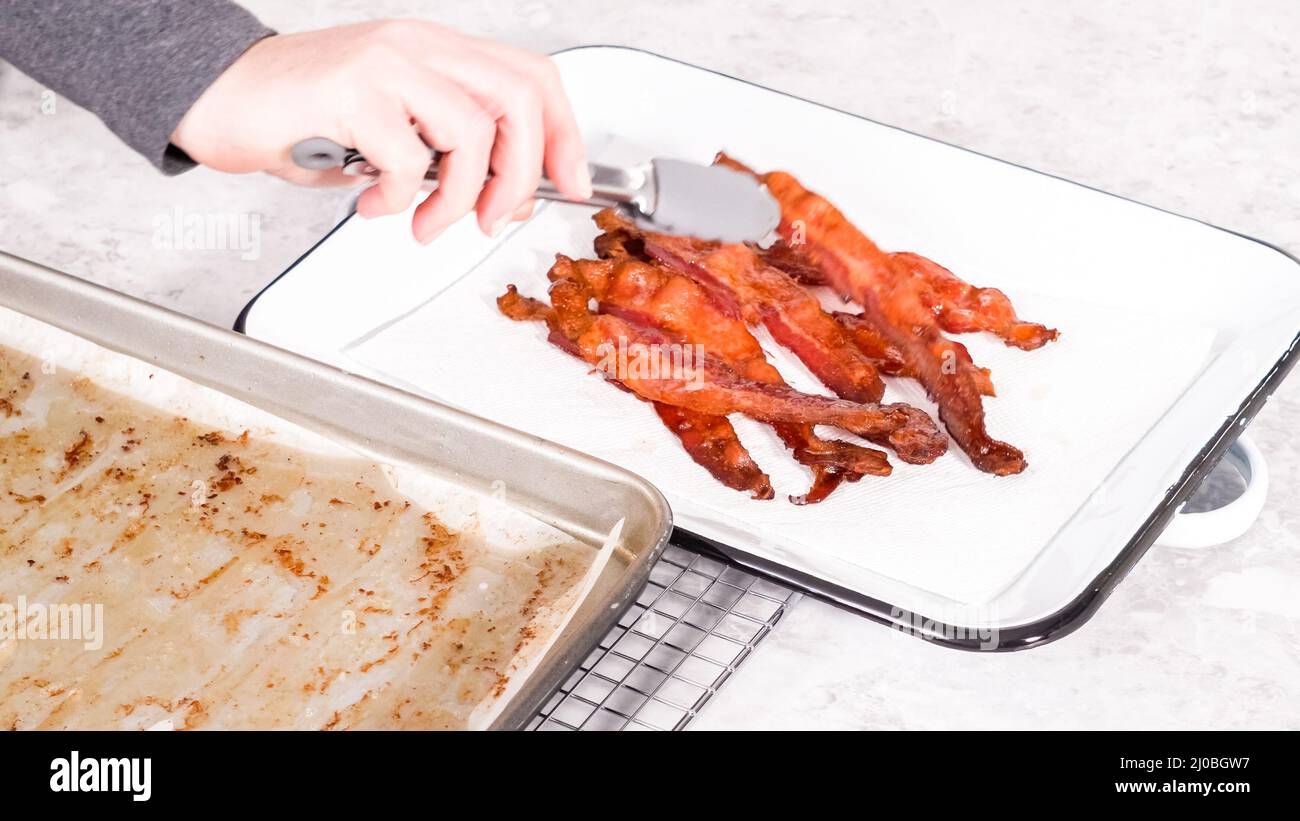 Step by step. Cooked bacon strips on a white tray with a paper towel