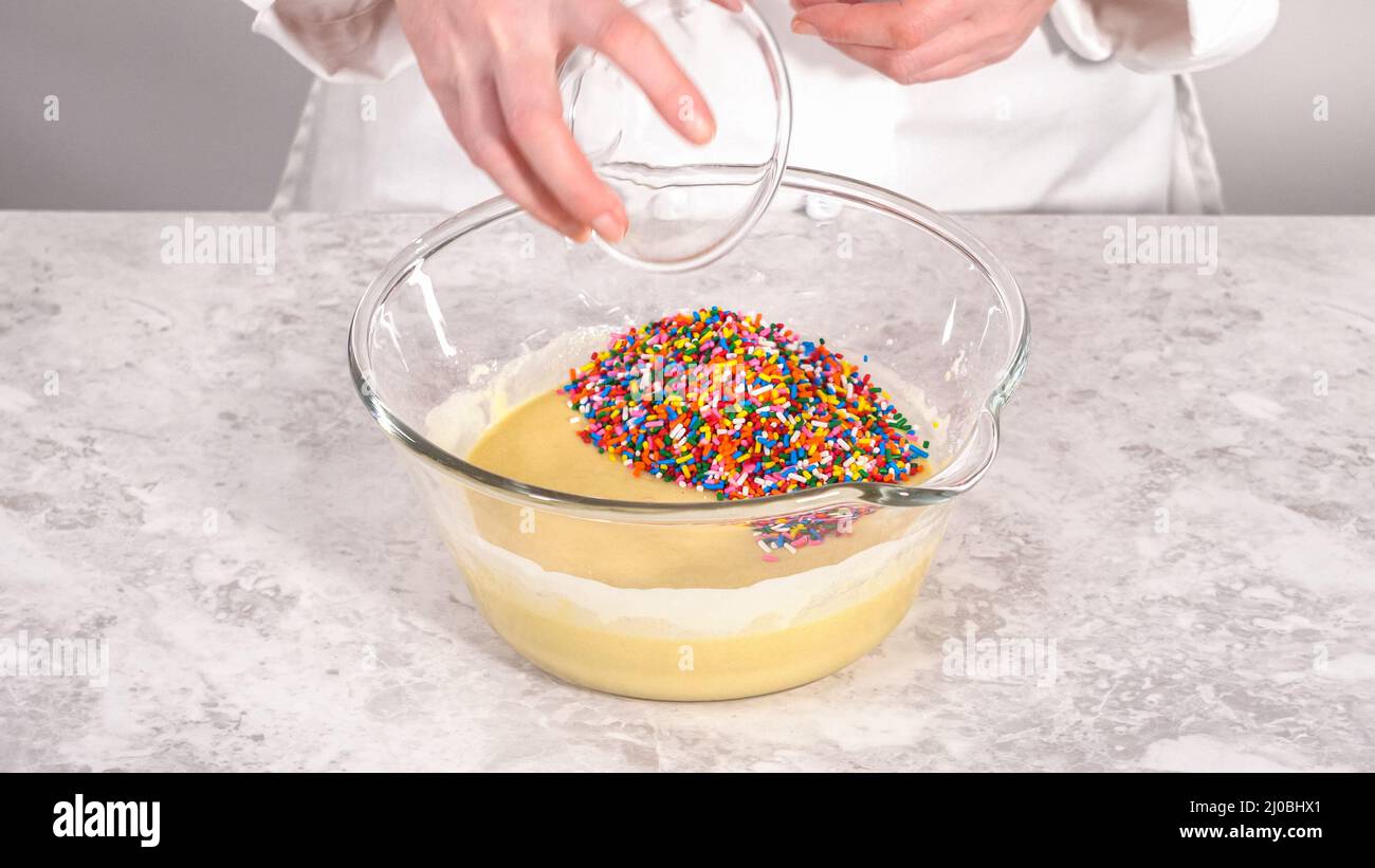 Step by step. Folding into the cake batter rainbow sprinkles to bake