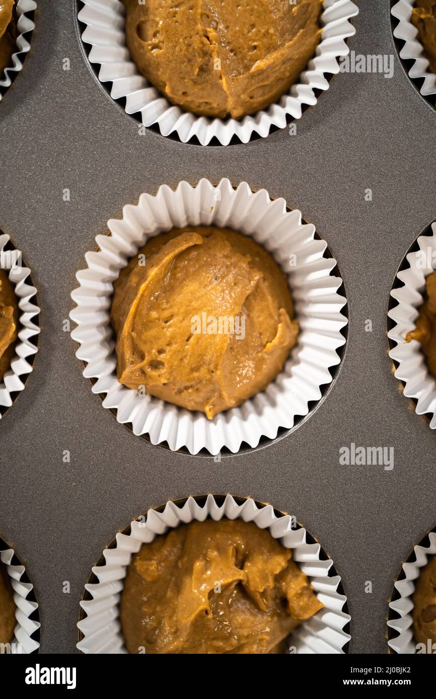 Scooping cupcake batter with a dough scoop into cupcake foil