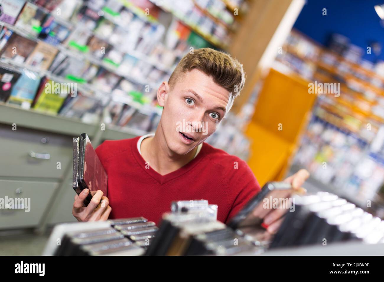 Surprised guy choosing DVD Stock Photo