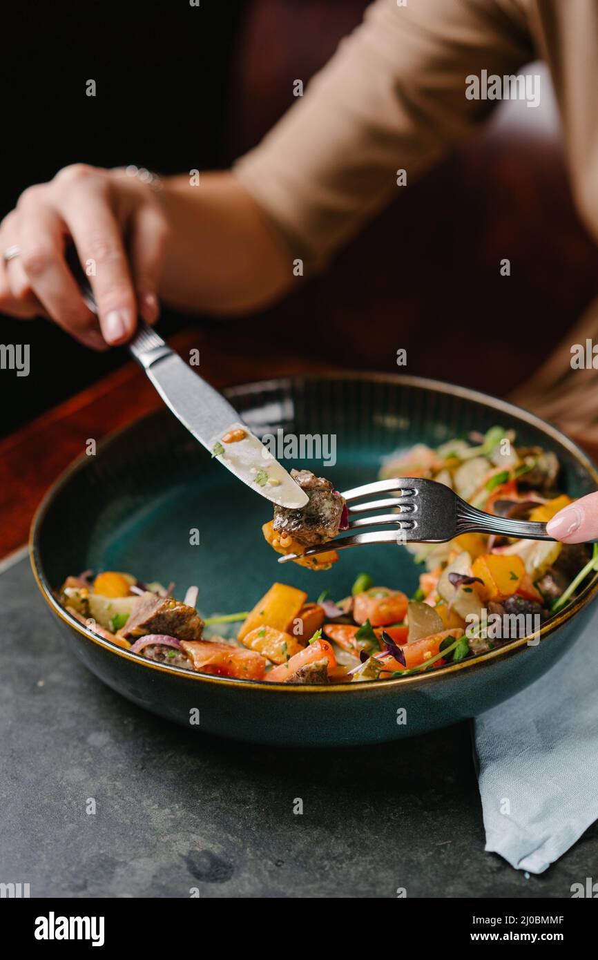 salad with stewed veal cheeks, potato wedges, tomatoes and mustard
