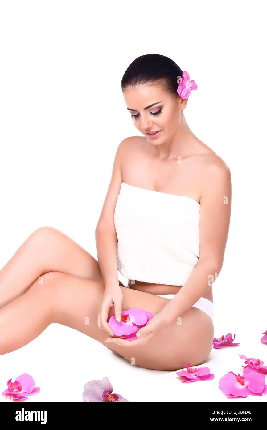 Beautiful brunette girl with orchid a perfect skin. Stock Photo