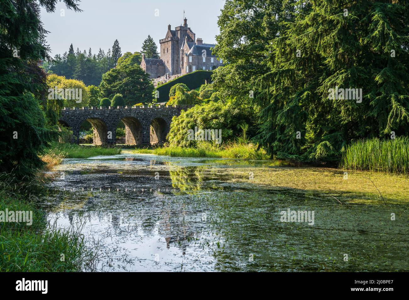 View of Drummond Castle and stone bridge from the pond - Drummond Castle near Crieff in Perthshire, Scotland, UK Stock Photo