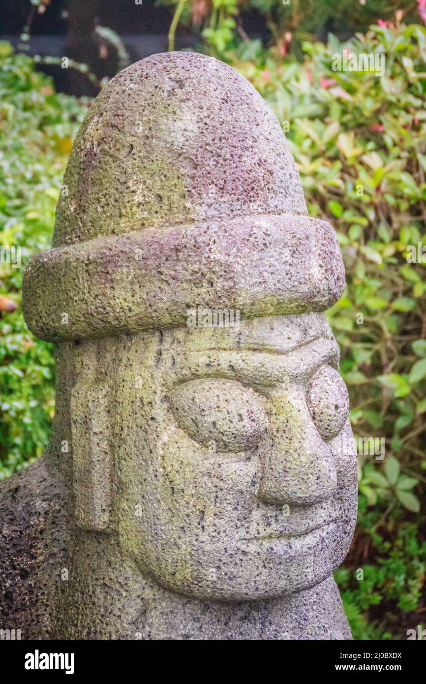 Close up face of the stone idol (Dolharubang, the grandfather stones) near by Jeju walking street, Stock Photo