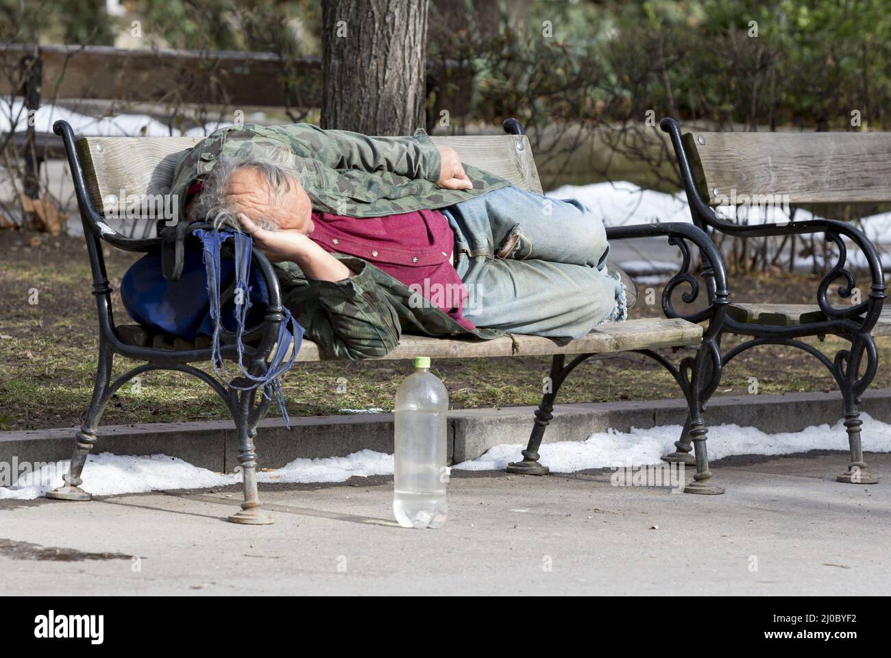 Homeless man sleeping on a bench Stock Photo Alamy