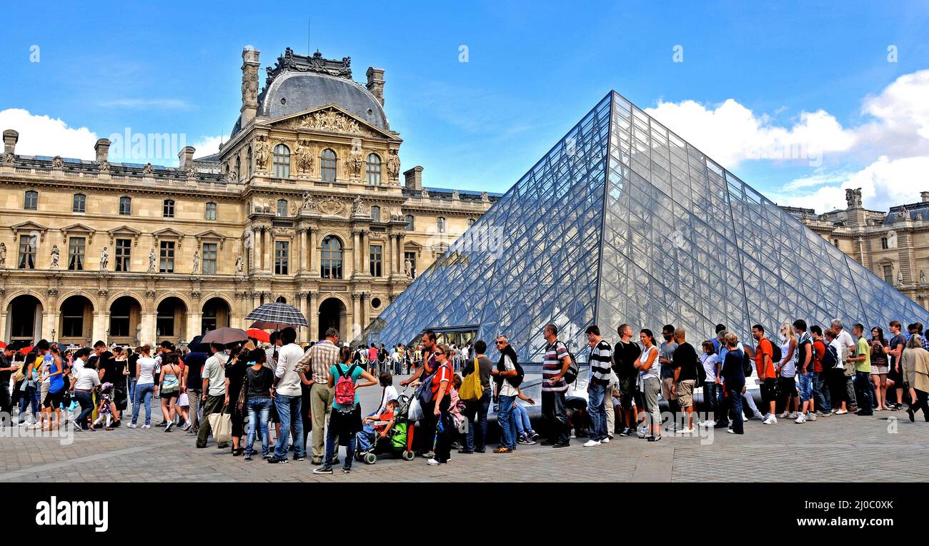 Tourists queue before the Pyranid of Louvre museum Paris France Stock Photo