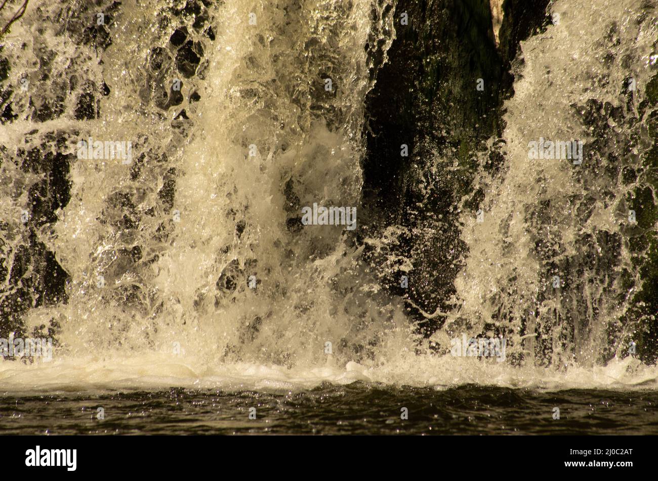 Close up of white water cascading into the pool at the bottom of a