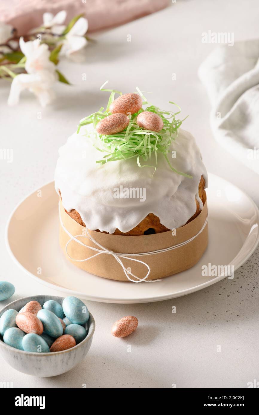 Easter festive cake and colorful eggs on white table. Close up. Vertical. Stock Photo
