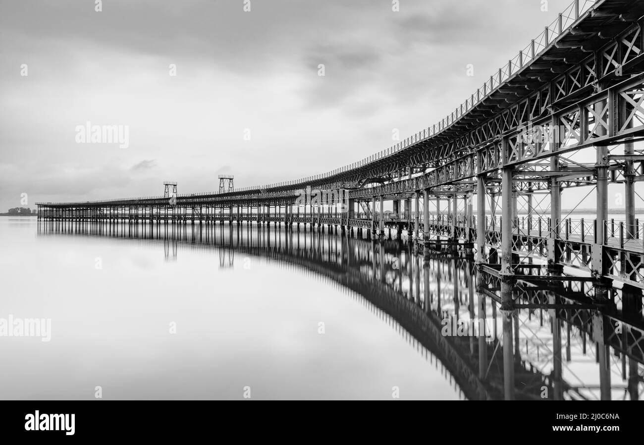 A black and white long exposure view of the historic Rio Tinto pier in Huelva Stock Photo