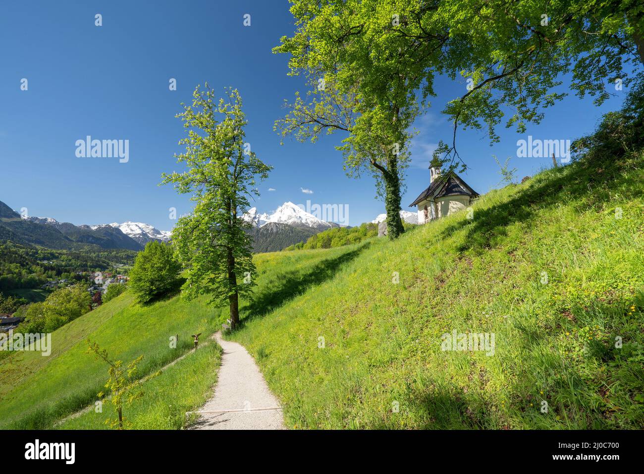 die Kirchleitn Kapelle am Mitterweinfeld hoch über Berchtesgaden mit dem maechtigen Watzmann im Hintergrund  im saftiggruenen Fruehsommer, Berchtesgad Stock Photo
