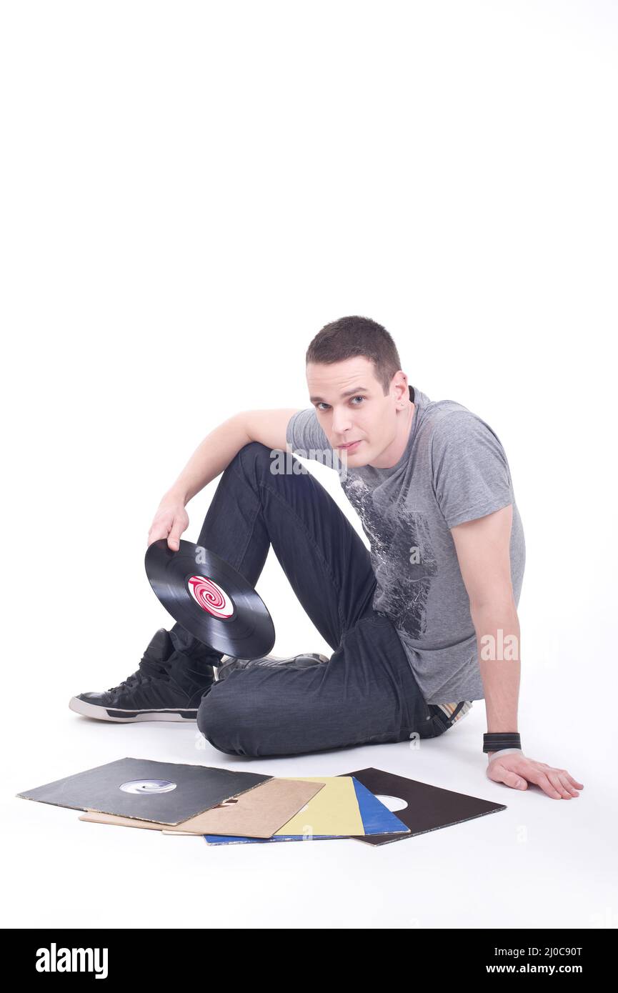 Young man sitting on the floor and review vinyl records Stock Photo