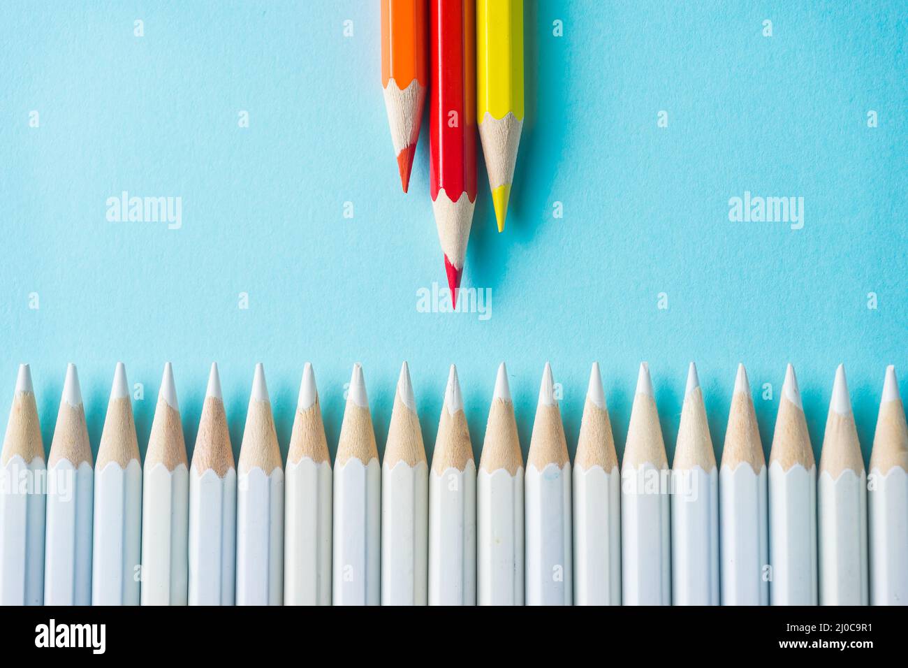 Business concept - lot of white pencils and color pencil on blue paper ...