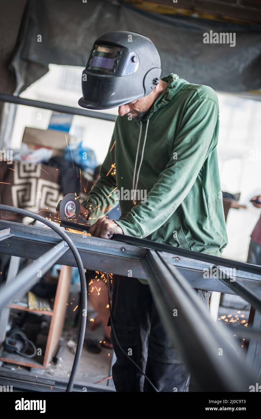 Electric wheel grinding on steel structure in factory. Sparks from the