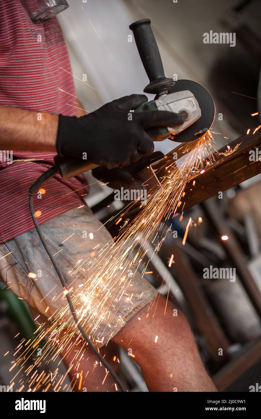 Electric wheel grinding on steel structure in factory. Sparks from the