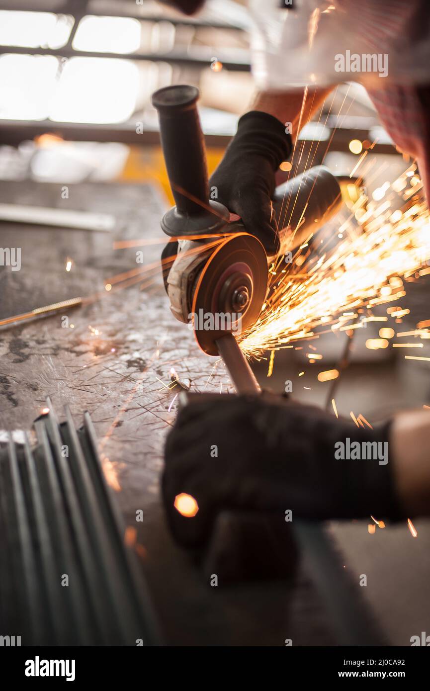 Electric wheel grinding on steel structure in factory. Sparks from the